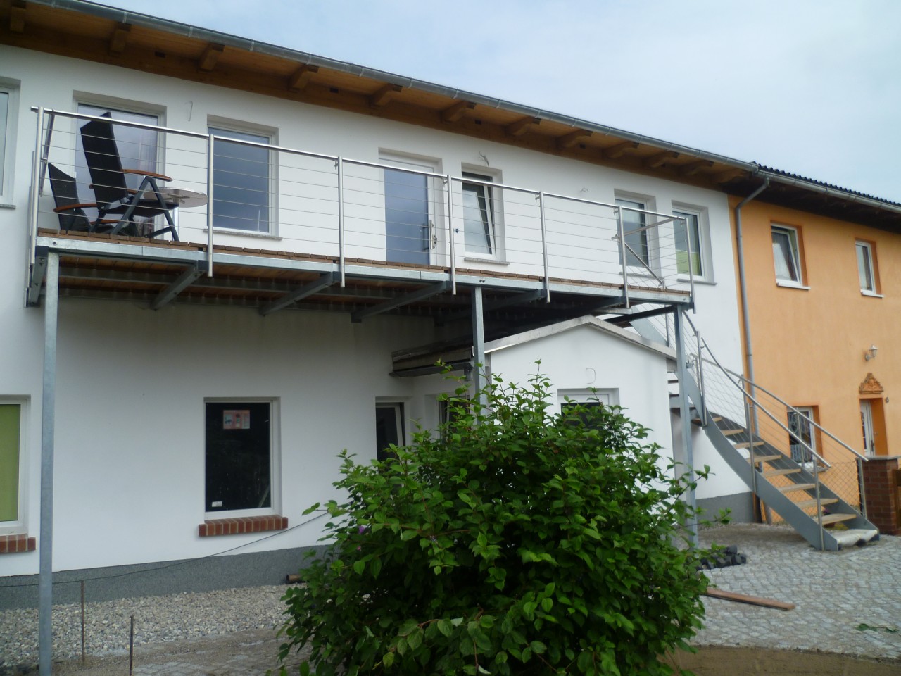 Stahlwangen-Außentreppe-verzinkt-mit-ES-Geländer-Lärchestufen-und-Balkon